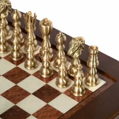 Pièces d'échecs dorées en laiton sur échiquier en marqueterie