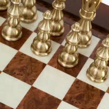 Pions et pièces d'échecs dorés sur cases en bois clair et foncé