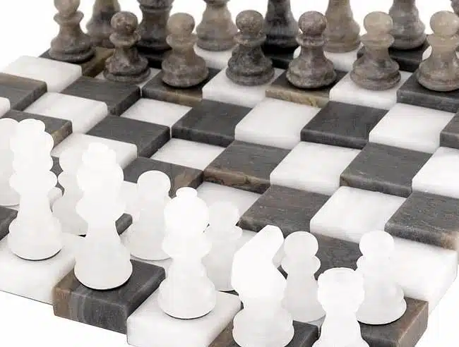 Rangée de pions en marbre gris et blanc face à face sur l'échiquier 3D