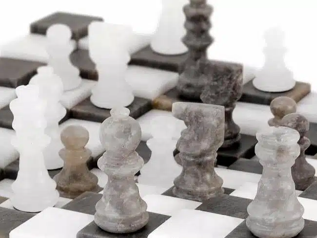 Gros plan sur le roi et les pièces en marbre gris et blanc de l'échiquier 3D