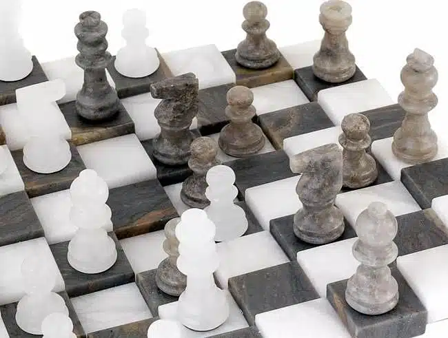 Détail des pièces d'échecs en marbre antique disposées en diagonale sur l'échiquier