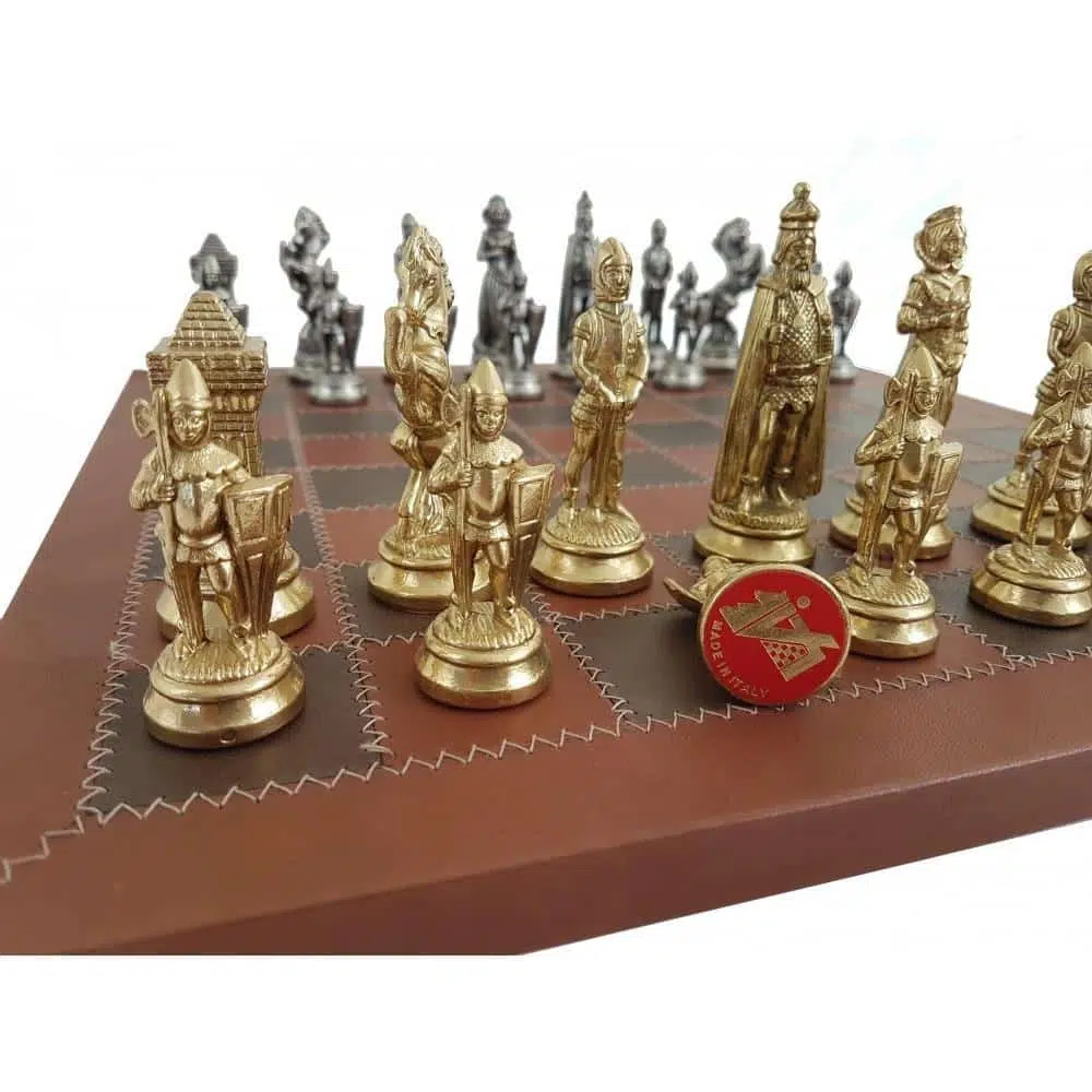 Pièces d'échecs métal doré et argenté posées sur l'échiquier en cuir, vue rapprochée