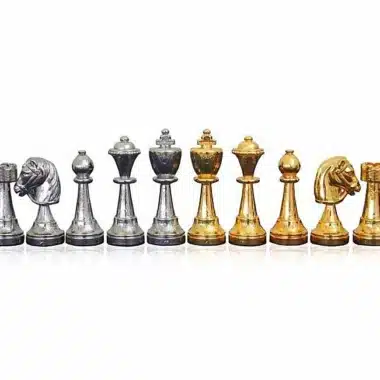 Pièces d'échecs en métal plaqué or et argent alignées, roi, dame, tour, fou, cavalier