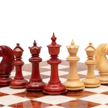 Pièces d'échecs en bois de padouk rouge et buis clair sur échiquier