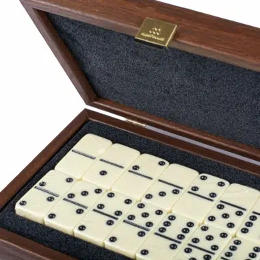 Vue rapprochée des dominos ivoire dans leur coffret en bois ouvert
