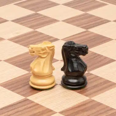 Cavaliers Highclere clair et foncé posés sur l'échiquier en érable et noyer