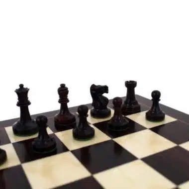 Pièces d'échecs foncées sur l'échiquier en bois de rose, vue rapprochée
