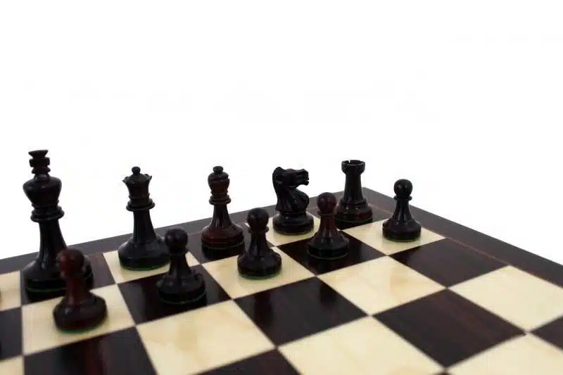 Pièces d'échecs foncées sur l'échiquier en bois de rose, vue rapprochée