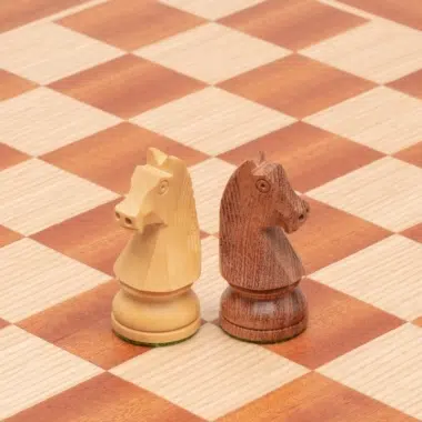 Cavaliers en bois de rose et buis posés côte à côte sur l'échiquier en acajou