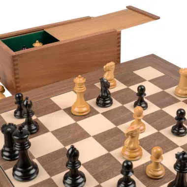 Coffret de rangement ouvert avec feutrine verte près des pièces en jeu